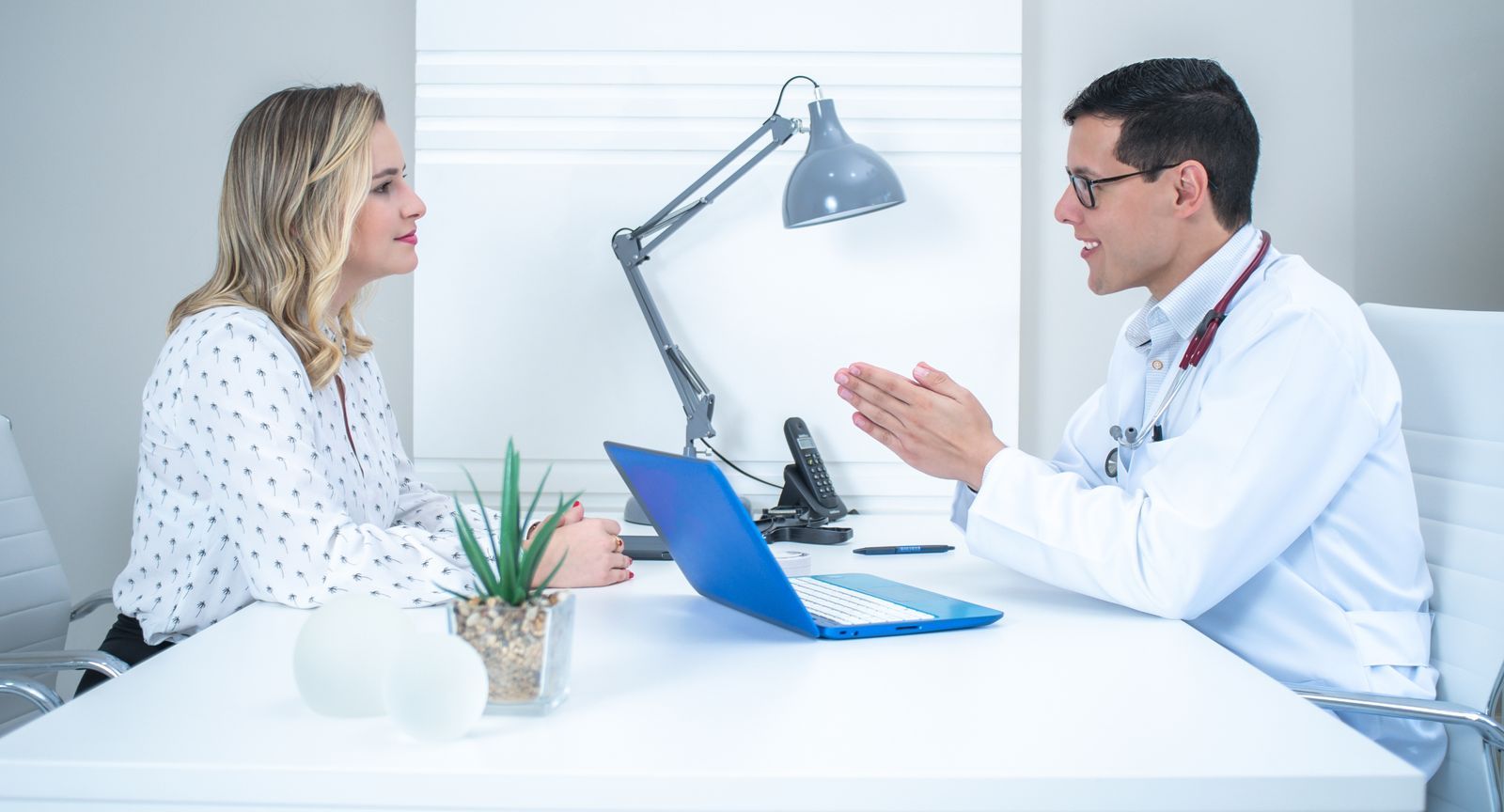 Doctor consulting a patient in a modern clinic (illustrative lifestyle photo — not a real patient, physician, or endorser).